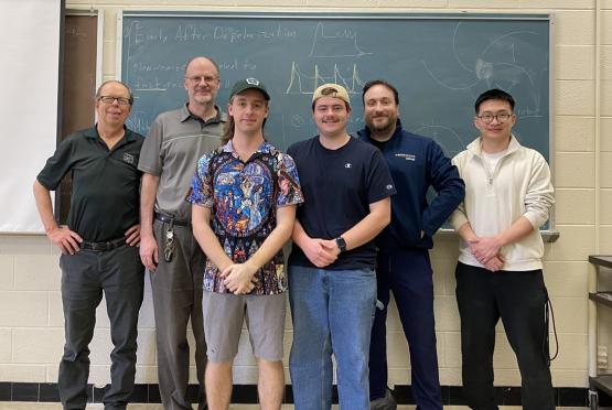 OHIO students, faculty and staff who work with the OSC stand together in front  of a chalkboard in an OHIO classroom