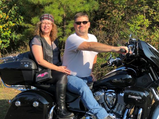 Tracy Watson and Corey Boby are shown sitting on a motorcycle