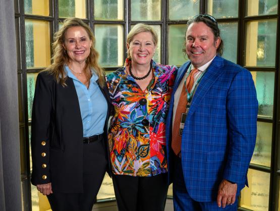 OHIO President Lori Stewart Gonzalez stands with two OHIO alumni at the luncheon