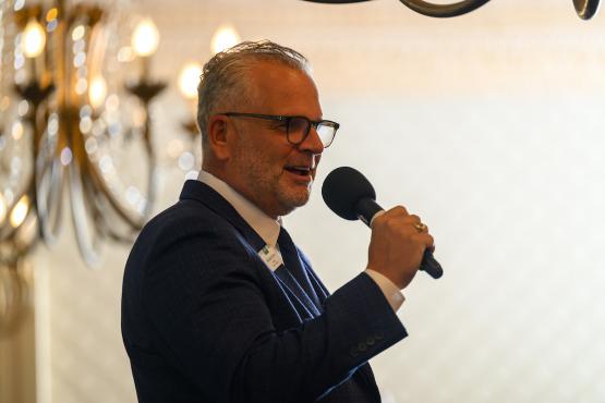 OHIO Board of Trustees Chair Matt Evans speaks into a microphone at the State Government Alumni Luncheon