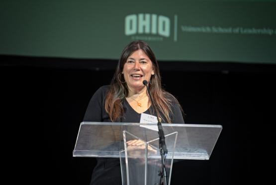 Tracy Plouck leads a presentation while standing at the podium in the Baker University Center at the State of the Region Conference