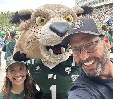Gregg Patner stands with OHIO&amp;#039;s Rufus mascot and another individual at an OHIO football game in Peden Stadium
