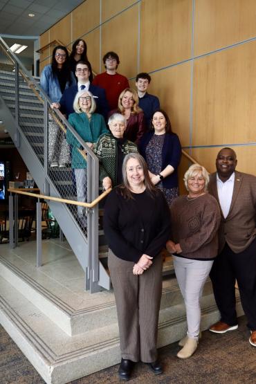 Martha Kline is shown with OHIO studetns, faculty and staff as they stand in a group on a staircase at Ohio University