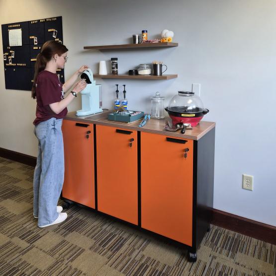 An OHIO student prepares coffee at the new coffee bar at the Writing Commons