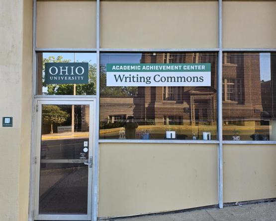 An image from the outside of the front door and front window of the Academic Achievement Center Writing Commons