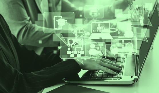 Hands type on a computer while graphic designs are shown above the computer