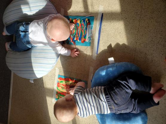 Two babies are shown crawling at the Child Development Center