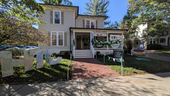 The outside of the Burtch House is decorated for Homecoming with green  and white balloons, a Homecoming sign and the letters HTC