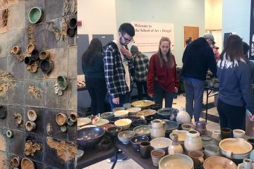 People looking at pottery displays