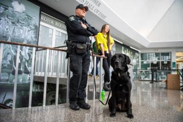 An OUPD K9 officer and his dog stand in the Convocation Center