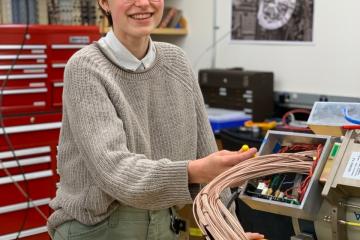 Emma Rice poses for a picture in the Lawrence Berkeley National Lab (LBNL), with the number 13 out of 30 total circuitries needed to build GRETA (Gamma Ray Energy Tracking Array)