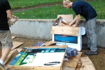 Zero Waste team member Brandt Taylor flattens move-in cardboard for recycling.