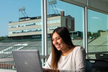 Girl working on laptop overlooking Peden Stadium