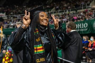 A recent graduate celebrates as she crosses the stage during the Fall Commencement 2021 at the Athens Campus.