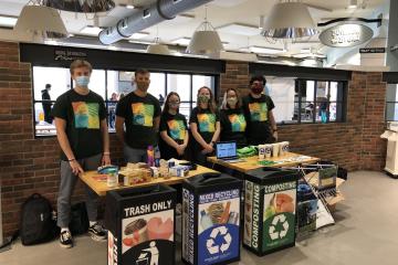 A group of Climate and Sustainability Ambassadors by recycling bins