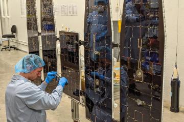 Tanner Wick, BSME ’19, is shown working on the solar array for NASA’a IXPE.