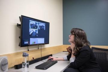 Dr. Stephanie Tikkanen, assistant professor in the School of Communication Studies, demonstrates the AVfusion software as she observes a group conversation taking place in the new COMS Research Lab.