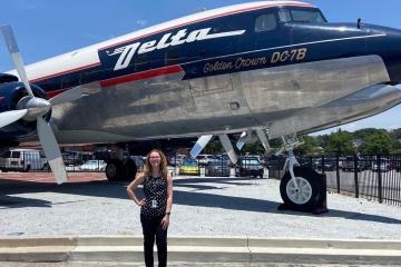 Ohio University student Madelynn Zarembka poses in front of a Delta airplane