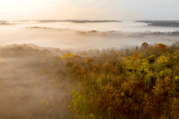 The sun rises over fog on the hills surrounding the Athens campus. 