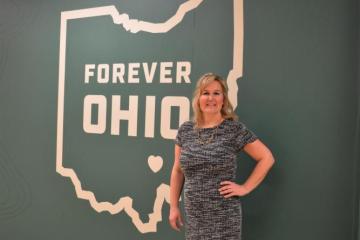 Photo of Heather Cameron in front of a large "Forever OHIO" graphic