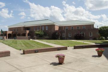 Photo of a brick-patterned campus building on a partly sunny day