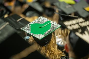 A photo of a  graduation cap that has a green Ohio on the top of it