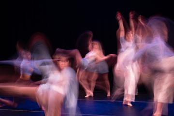 a blurred image of multiple dancers moving and overlapping