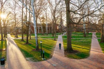 A staff member walks across College Green.