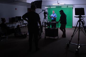 Local police officer in front of a green screen in the Grid Lab during an ALEI exercise