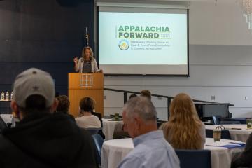 A speaker is shown giving a presentation at the 2023 Appalachia Forward Conference