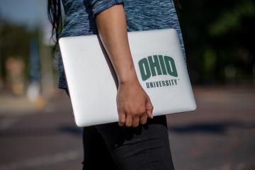 An OHIO student holds a laptop computer