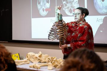 Sabrina Curran, Ph.D., examines fossil replicas of early humans and primates in front of her Introduction to Biological Anthropology class on Sept. 28, 2023.
