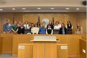 pre-law students pose for photo in courtroom