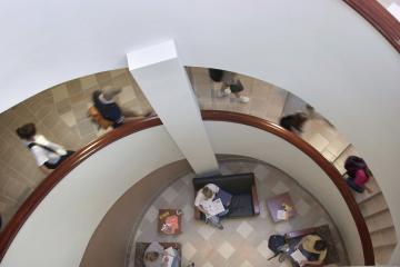Students walk on interior staircase at Grover Center