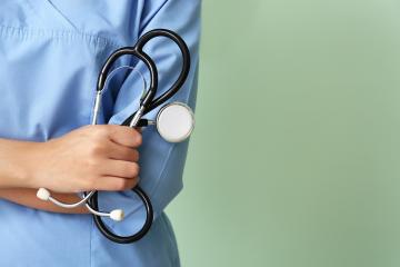 A healthcare professional is shown holding a stethoscope