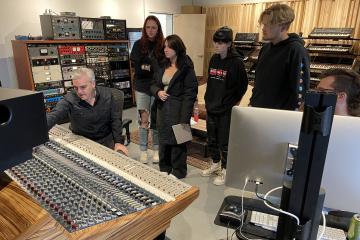 Students observe as producer Jim Eno adjusts a mixing console in Public Hi-Fi Studios.