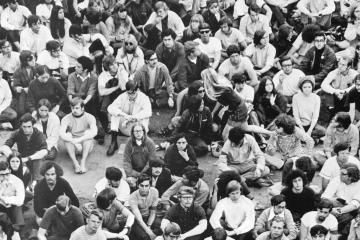 People sit across a sidewalk in protest in 1970