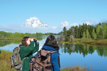 Grace Cahill spots birds at Oxbow Bend in Grand Teton National Park—a popular fauna-spotting location—while Lou Duloisy watches Mount Moran emerge from behind the morning fog