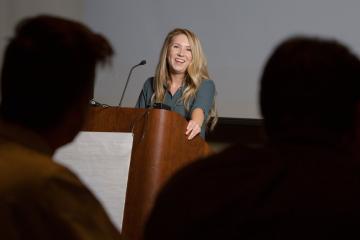 Portrait photograph of Laurel Monroe standing at a podium
