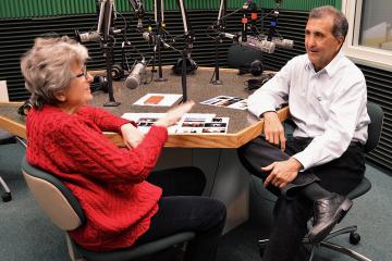Pete Souza sitting at a table with former colleague Marcia Nighswander, conducting a radio interview