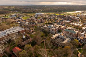 A drone photograph of Ohio University's campus, with College Green in the foreground and the Convocation Center in the distance