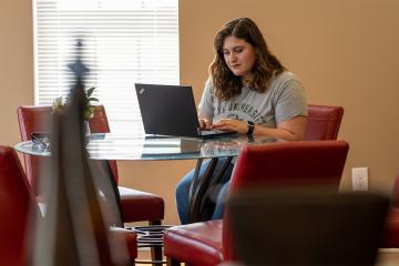An OHIO Online student at a kitchen table working to earn their master's in English. 