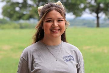 Young female with brown hair, wearing grey t-shirt