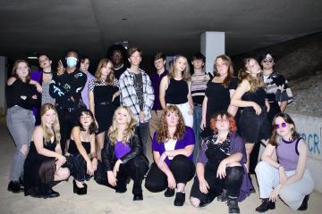 The members of Dynamics Acapella pose wearing purple and black