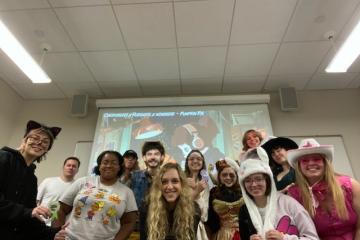 A group of people in costumes pose together, smiling at the camera