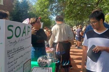 A student peruses the display for SOAP at the Student Organization Fair