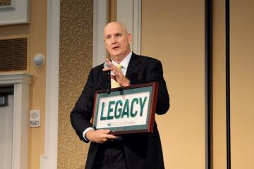 Greg Moran holds a sign that says "Legacy" during an OHIO event