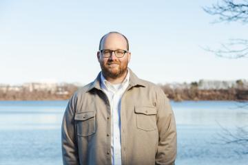 Philip Eil standing in front of body of water