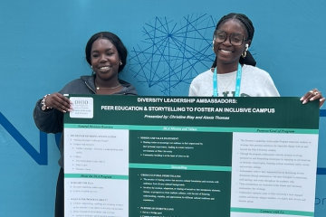 Student pose with their presentation at conference