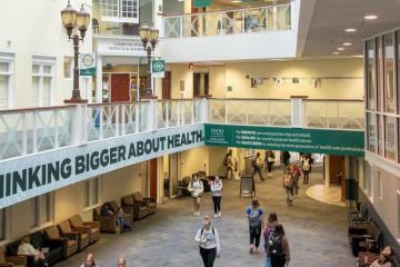 A photo from the second floor looking down at students walking through the Grover Center Atrium